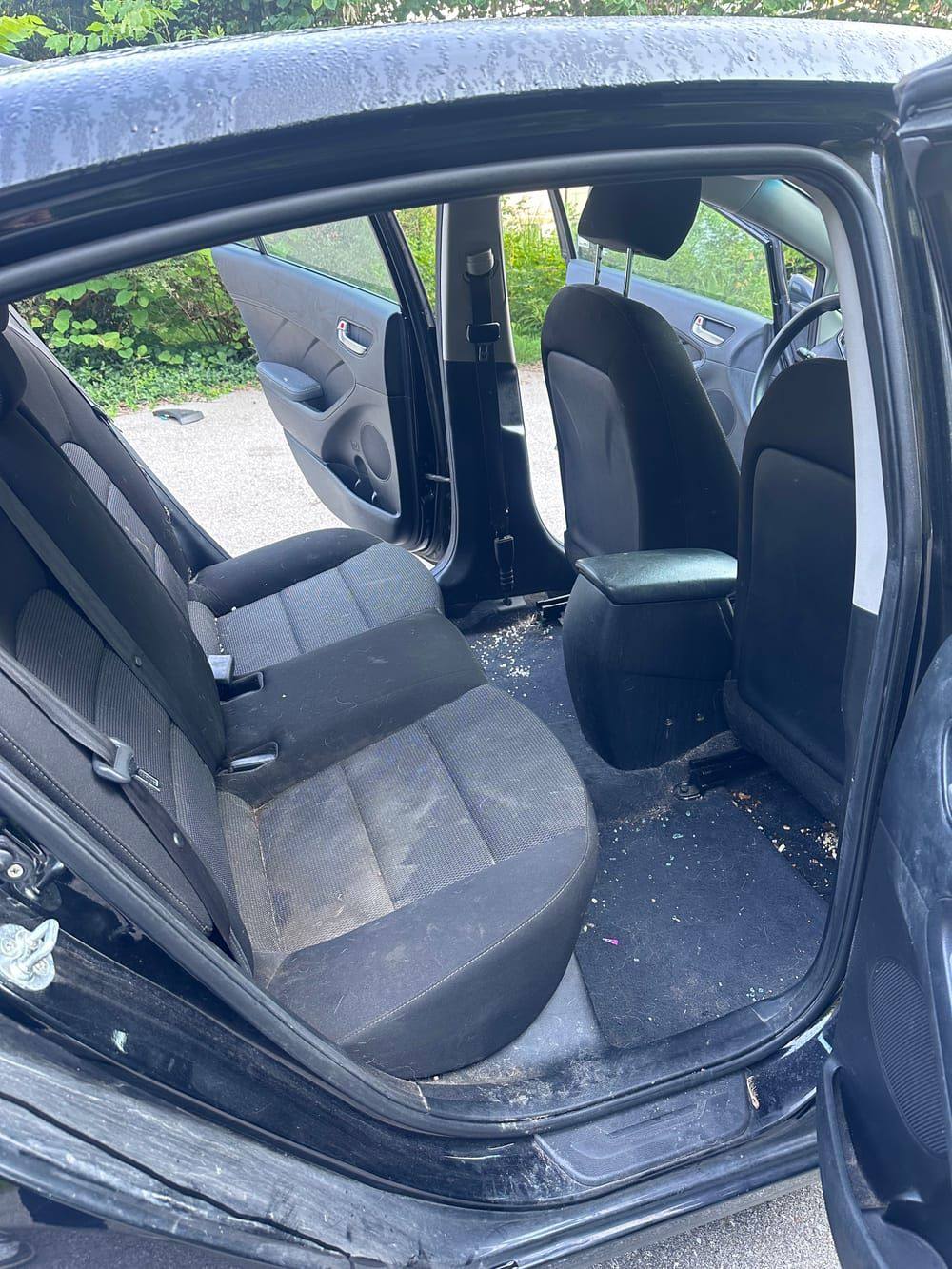 Car back seat with crumbs and dirty cloth upholstery before interior detailing